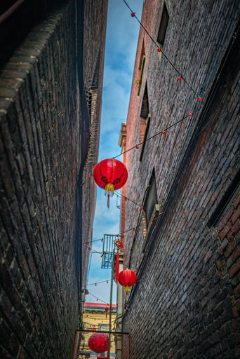 A vertical low angle shot of Chinese lanterns in Fan Tan Alley, Chinatown, Victoria, BC Canada