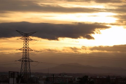 A yellow cloudy sky during the sunset with high a voltage electric pole in Valencia, Spain