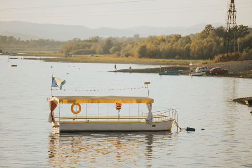 Small boats sailing over a background of an orange sunset