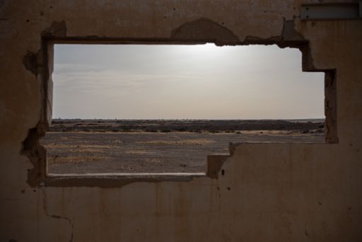 The Negev desert view seen through a cracked weathered wall opening made of concrete