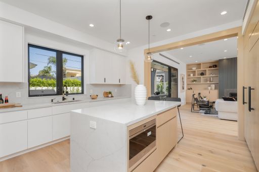 A modern kitchen with white cabinetry and a clean, minimalist design