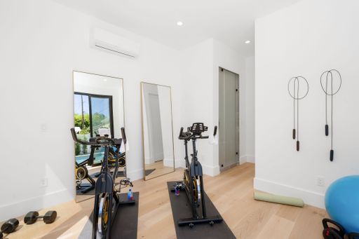 A spacious gym room featuring modern workout equipment and a large open area for exercising