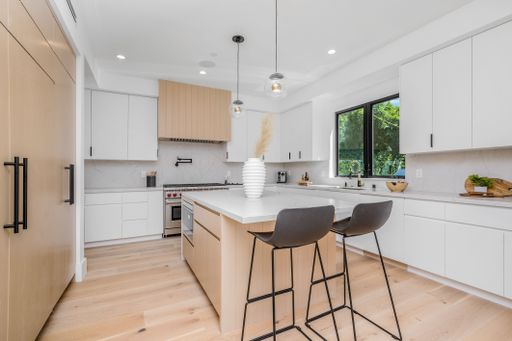 A contemporary kitchen filled with classic white cabinetry and countertops