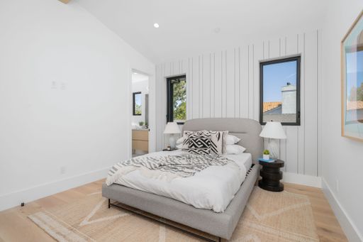 A modern master bedroom interior features a contemporary wallpaper design, as well as a new overhead ceiling fan for added air circulation