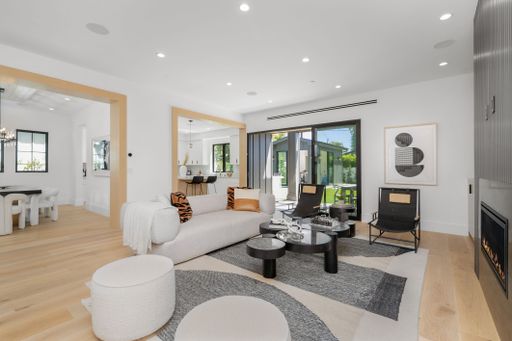 A stylish modern living room features a white furniture and decor set, creating a bright and inviting atmosphere