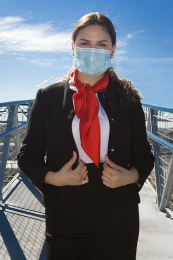 A vertical shot of a Caucasian woman wearing a sanitary mask outdoors-concept of the new normal