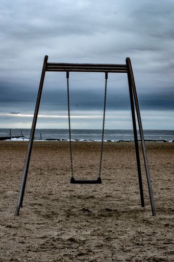 A vertical shot of a swing on sandy beach in Borkum, Germany
