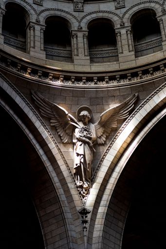 A vertical shot of a beautiful angel statue on the wall inside the Saint Clotilde basilica in Paris