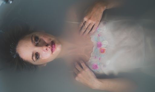 An overhead shot of a beautiful young woman having a relaxing milk bath