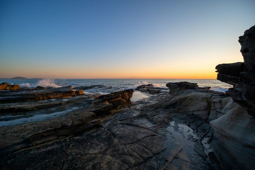 A mesmerizing shot of a rocky shore at the sunset