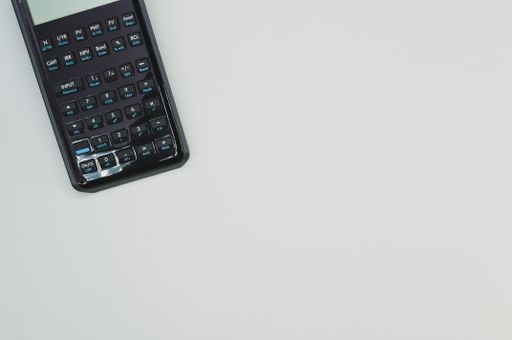 A top view of a scientific calculator on pastel gray background with an empty space for a text