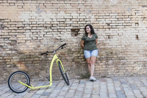 A female resting by the wall after riding her bicycle