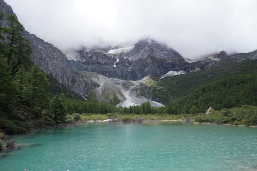 A lake and cloud-capped mountains in the Daocheng Yading National Park, Sichuan, China.