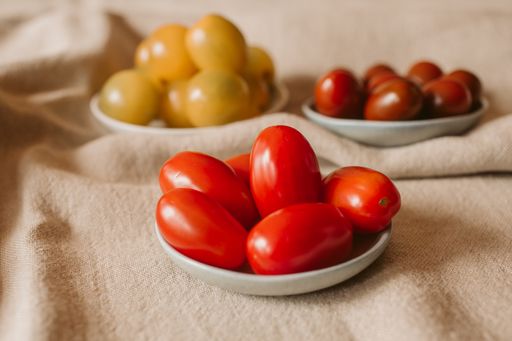 Different Kinds of Organic Baby Tomatoes in a Bowl. Red and yellow tomatoes on rustic background. Organic and healthy food.