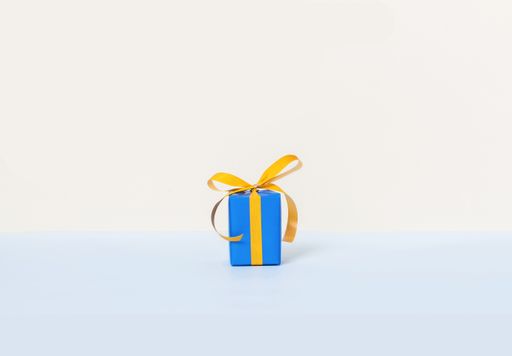 A blue gift box with yellow ribbon on a pastel background and space for your text