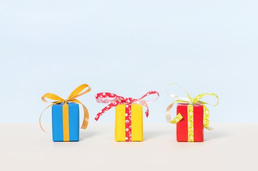 A row of colorful gift boxes with ribbons on pastel background with space for your text