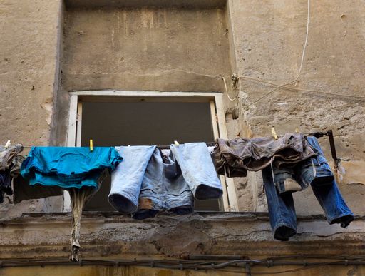 A low angle shot of drying laundry hanging outside an old building