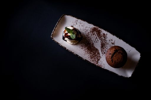 A top view of ice cream scoop and chocolate muffin isolated on black background