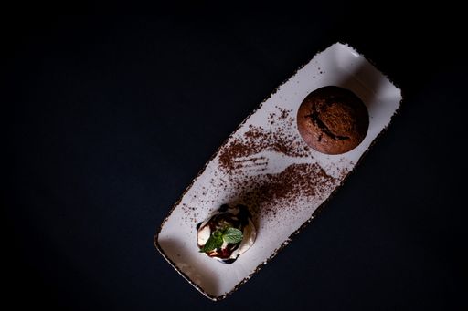 A top view of ice cream scoop and chocolate muffin isolated on black background