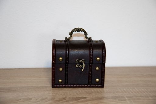 A closed brown treasure chest on a wooden surface
