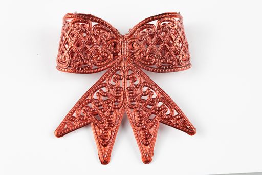 A closeup of a red bow Christmas ornament isolated on a white background