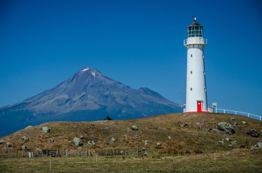 The Cape Egmont Lighthouse with the Mountain Taranaki on the background in Pungarehu, New Zealand
