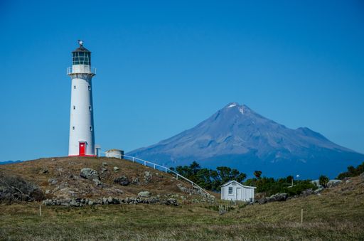 The Cape Egmont Lighthouse with the Mountain Taranaki on the background in Pungarehu, New Zealand