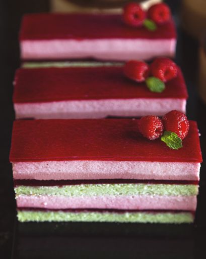 A vertical shot of delicious layered raspberry cake pieces on the table
