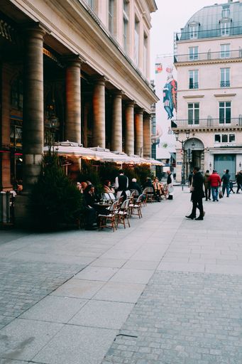 A view of an outdoor cafe surrounded by nice modern buildings during daytime