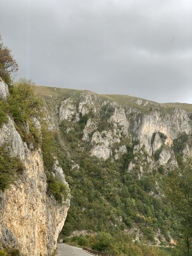 A vertical shot of mountains covered in greenery under a cloudy sky - great for wallpapers