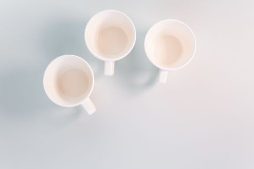 A top view of empty white coffee cups placed on a white surface