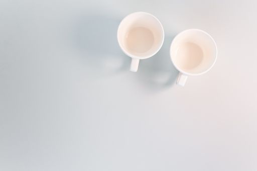 A top view of empty white coffee cups placed on a white surface