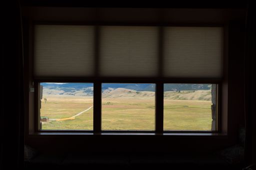 A beautiful lush landscape in Jackson, Wyoming seen from a window in a dark room