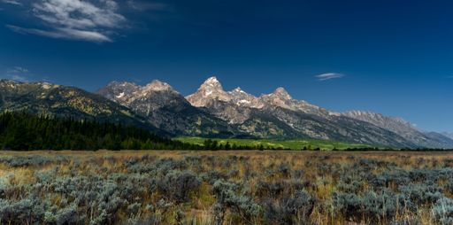 The Grand Teton National Park landscape with greenery and high hills against the blue sky in Wyoming