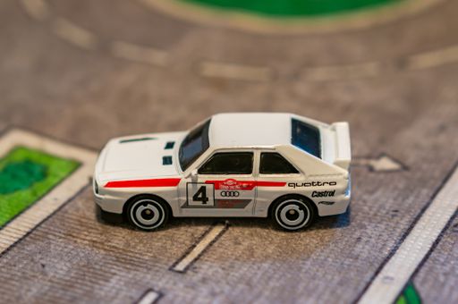 Mattel Hot Wheels white Audi Quattro toy model sport car on a play road mat.