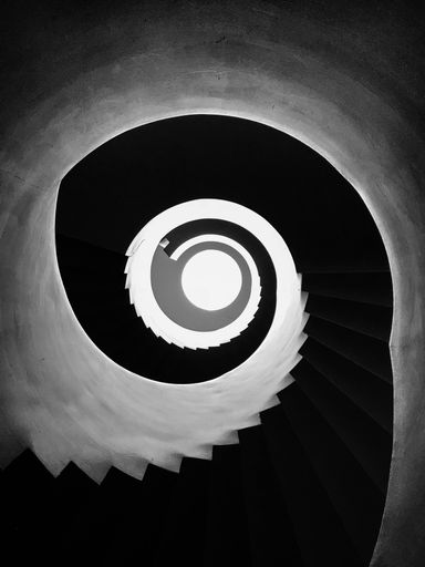 A vertical low angle shot of spiral black and white stairs