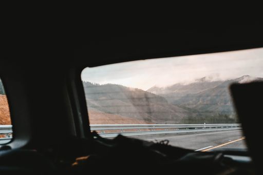 A beautiful scenery of high rocky mountains - a shot taken through a car window