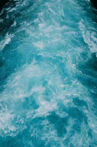 A vertical shot of the foamy waves of water in the sea