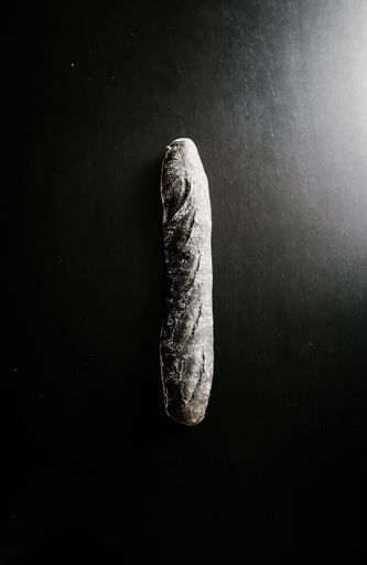 A vertical high angle shot of a black bread on a black surface