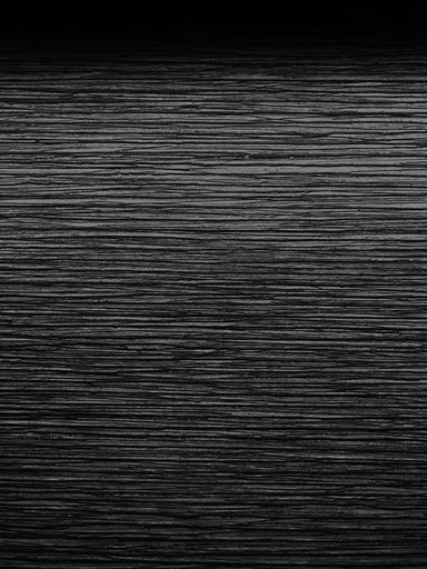 A vertical grey scale shot of a wooden table