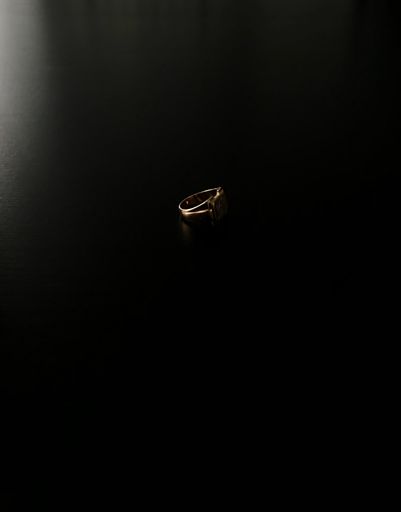 A vertical shot of a rose gold ring on a black surface