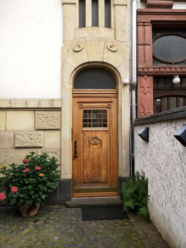 A vertical shot of an apartment with a wooden door