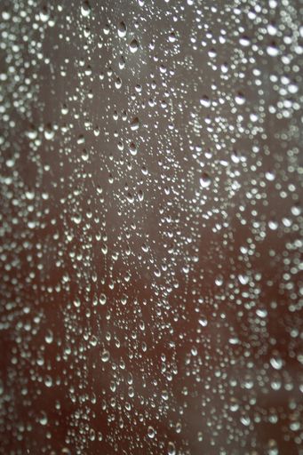 A vertical shot of a glass with water drops