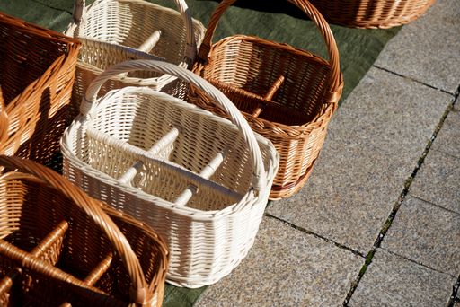 A high angle shot of thatched picnic baskets on the ground under the sunlight