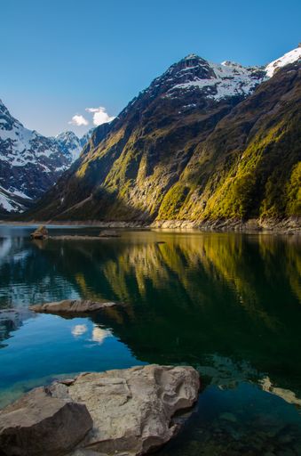 A vertical shot of the Lake Marian and mountains in New Zealand