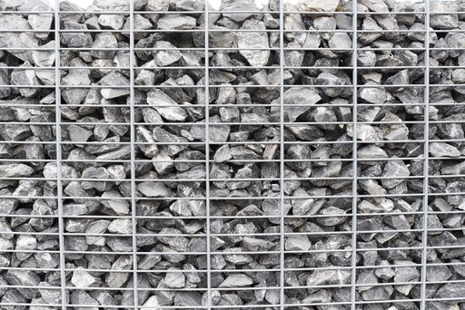 A cool background of a lot of rocks behind a metal fence - great for background or wallpaper