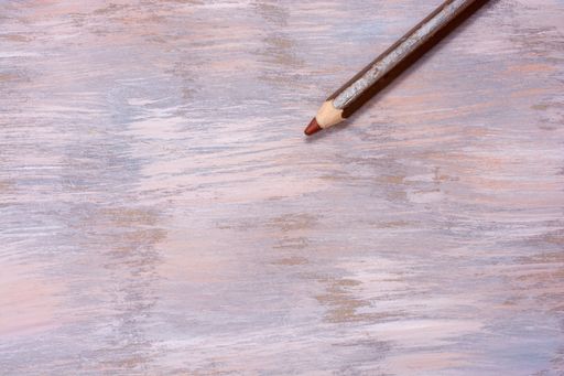 A top view shot of a brown pencil isolated on a colorful backdrop