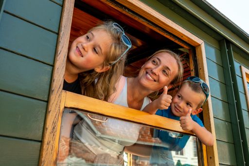 A mother and her children looking out the window of a train