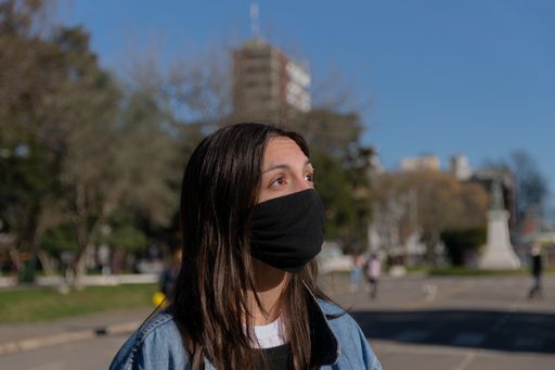 A closeup shot of a young lady  wearing a sanitary mask outside - concept of the new normal
