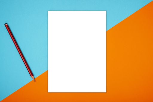 A top view of a blank sheet of paper with a pencil on orange and blue background with space for text